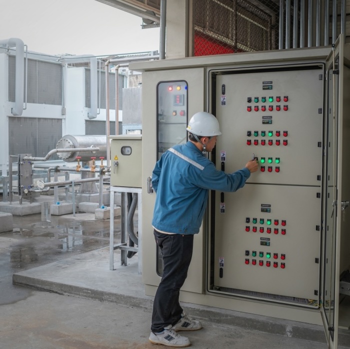 A worker looking at energy controls