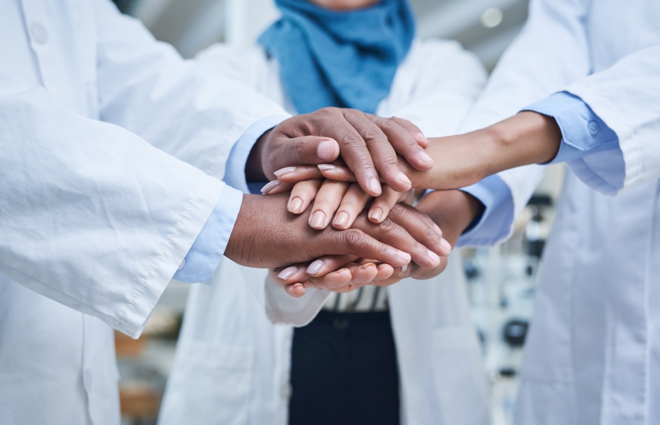 hand pile of scientists wearing white coats